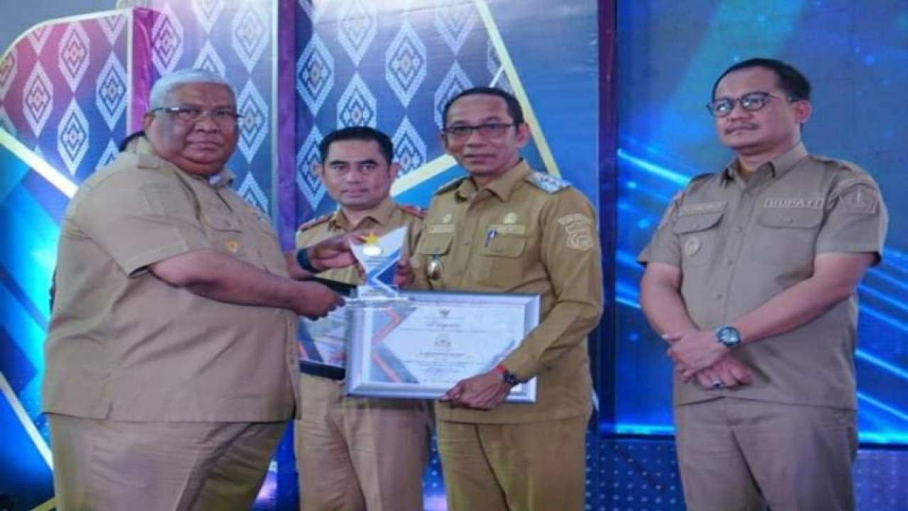Gubernur Sultra Ali Mazi (kiri) saat menyerahkan penghargaan kepada Pj Bupati Buton, Basiran (kedua kanan) karena dinilai baik dalam menangani stunting, di Baubau, Senin (20/3/2023) (ANTARA/HO-Kominfo Buton)