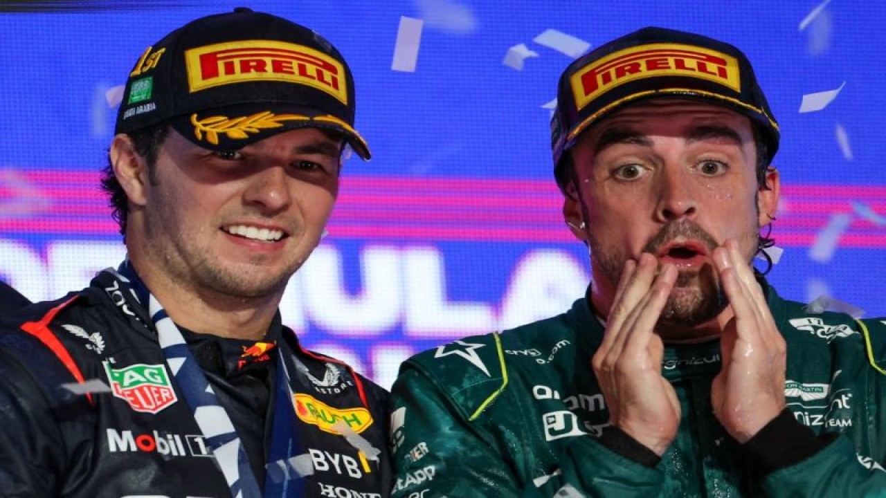 Pebalap tim Aston Martin Fernando Alonso (kanan) bereaksi di podium setelah finis ketiga Grand Prix Arab Saudi di Sirkuit Jeddah Corniche, Jeddah. (19/3/2019) (AFP/GIUSEPPE CACACE)