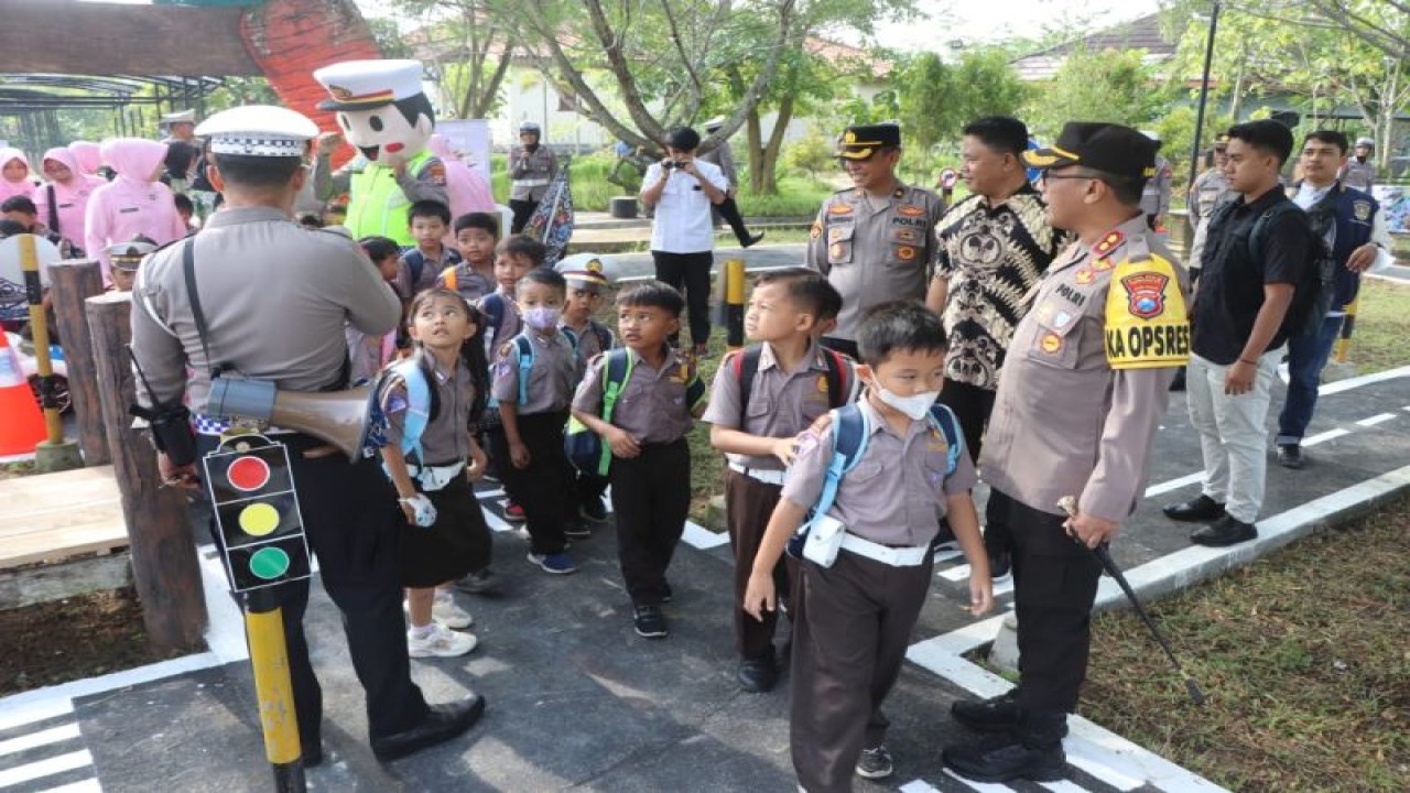 Petugas memandu dan mengedukasi pengunjung anak tentang tata tertib lalu lintas lewat sebuah permainan di Taman Lalu Lintas yang ada di dalam kmpleks wisata Agropark, Trenggalek, Senin (27/3/2023) (ANTARA/HO - Humas Polres Trenggalek)