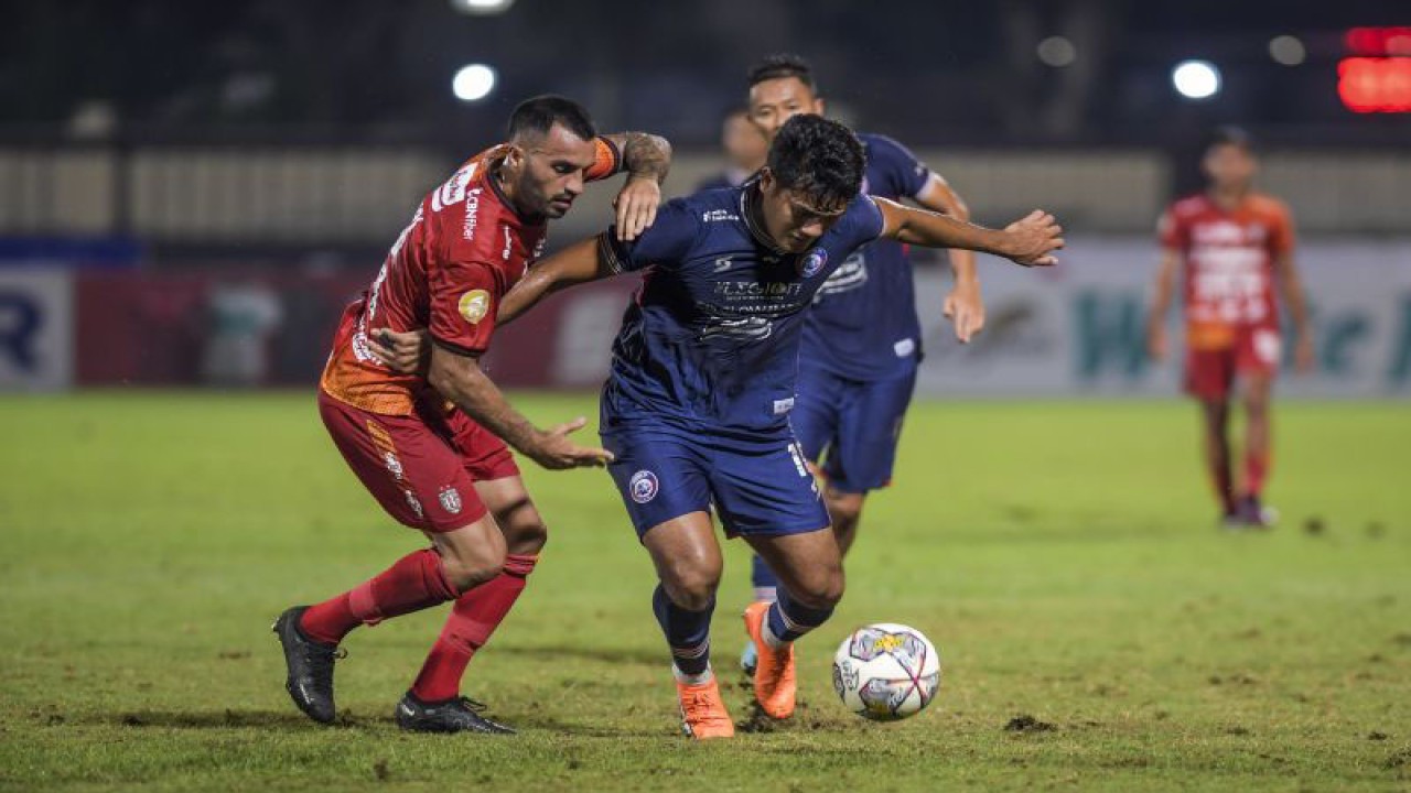 Pesepak bola Arema FC M Rafli (kanan) berusaha melewati hadangan pesepak bola Bali United Brwa Nouri (kiri) dalam lanjutan Liga 1 di Stadion PTIK, Jakarta, Senin (27/3/2023). Arema FC kalah atas Bali United dengan skor 1-3. ANTARA FOTO/Galih Pradipta/rwa (ANTARA FOTO/GALIH PRADIPTA)