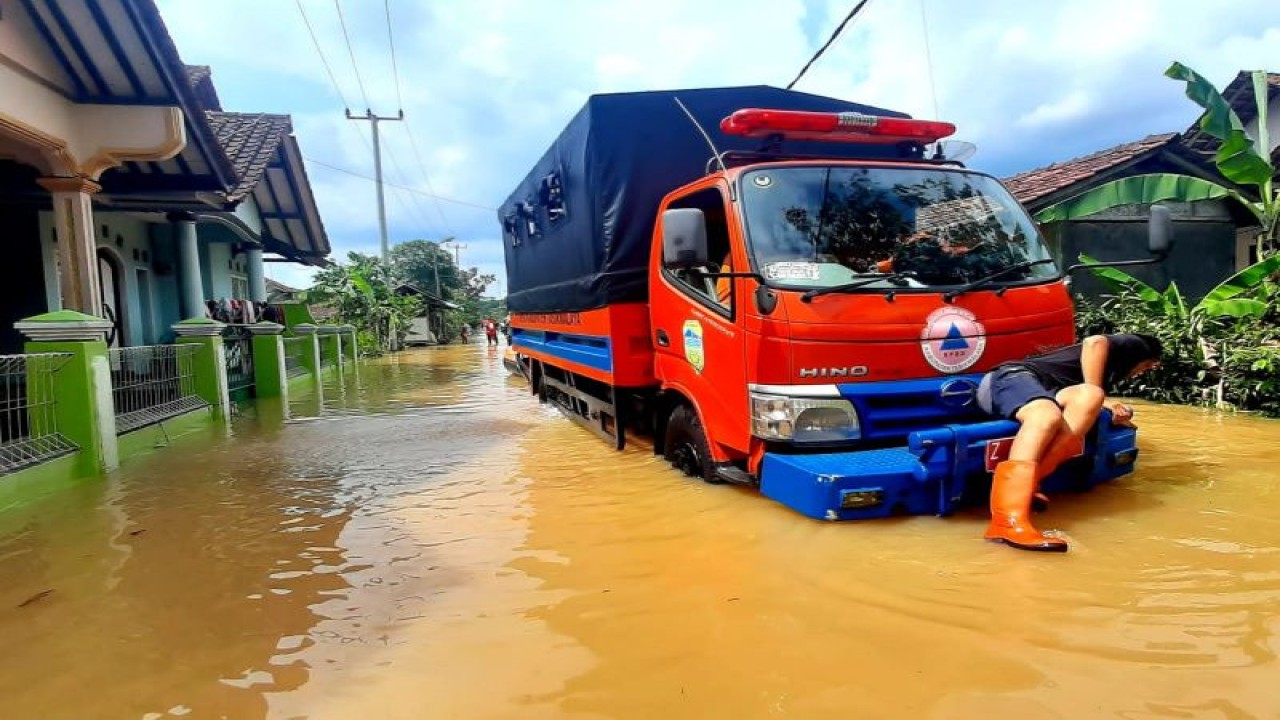 Sejumlah petugas memberikan bantuan kepada warga korban banjir di Desa Tanjungsari, Kecamatan Sukaresik, Kabupaten Tasikmalaya, Jawa Barat, Kamis (9/3/2023). (ANTARA/HO-BPBD Tasikmalaya)
