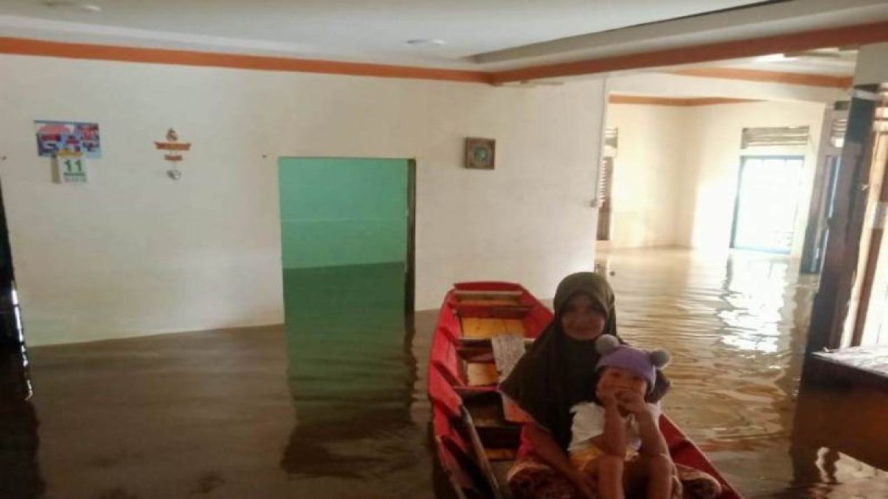 Warga Sepantai di dalam sampan di rumahnya yang banjir. (ANTARA/Feri)