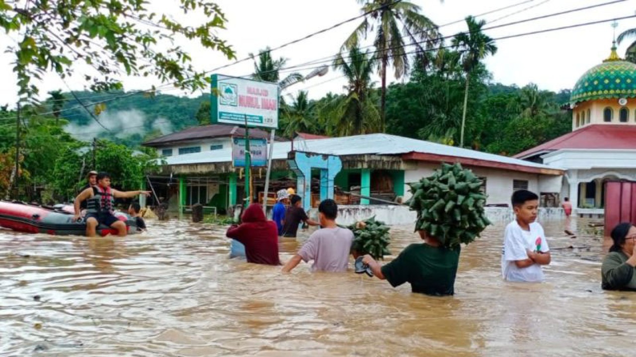 Sejumlah warga Kampung Tarandam, Kecamatan Sungai Pagu menerobos banjir pada Minggu (19/3/2023) yang menggenangi daerah itu akibat luapan Batang Suliti. ANTARA/Erik