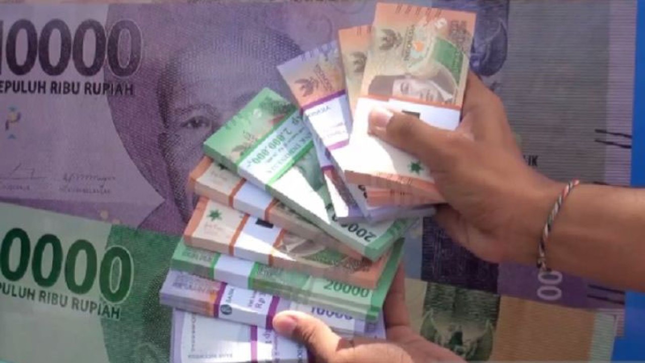 Warga menunjukkan uang pecahan hasil penukaran di mobil kas keliling Bank Indonesia, di Palangka Raya, berapa waktu lalu. (ANTARA/Redianto Tumon)