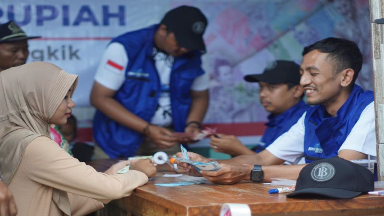 Seorang ibu rumah tangga menukarkan uang Rupiah tidak layak edar di layanan kas keliling Ekspedisi Rupiah Berdaulat (ERB) 2023, di pulau 3T di NTB. (ANTARA/HO-BI)