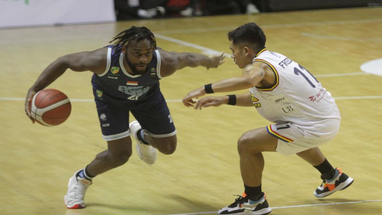 Pebasket Evos Thunder Bogor David Haye (kiri) berusaha melewati pebasket Elang Pacific Caesar Surabaya Dio Freedo Putra (kanan) saat pertandingan Indonesian Basketball League (IBL) 2023 Seri III di DBL Arena, Surabaya, Jawa Timur, Senin (13/2/2023). Evos Thunder Bogor mengalahkan Elang Pacific Caesar Surabaya dengan skor akhir 89-63. ANTARA FOTO/Moch Asim/rwa. (ANTARA FOTO/MOCH ASIM)