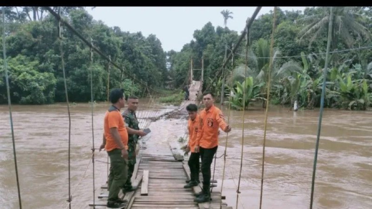 Jembatan gantung di Kabupaten OKU nyaris tenggelam akibat air sungai mulai meninggi, Senin (13/3). (ANTARA/Edo Purmana)