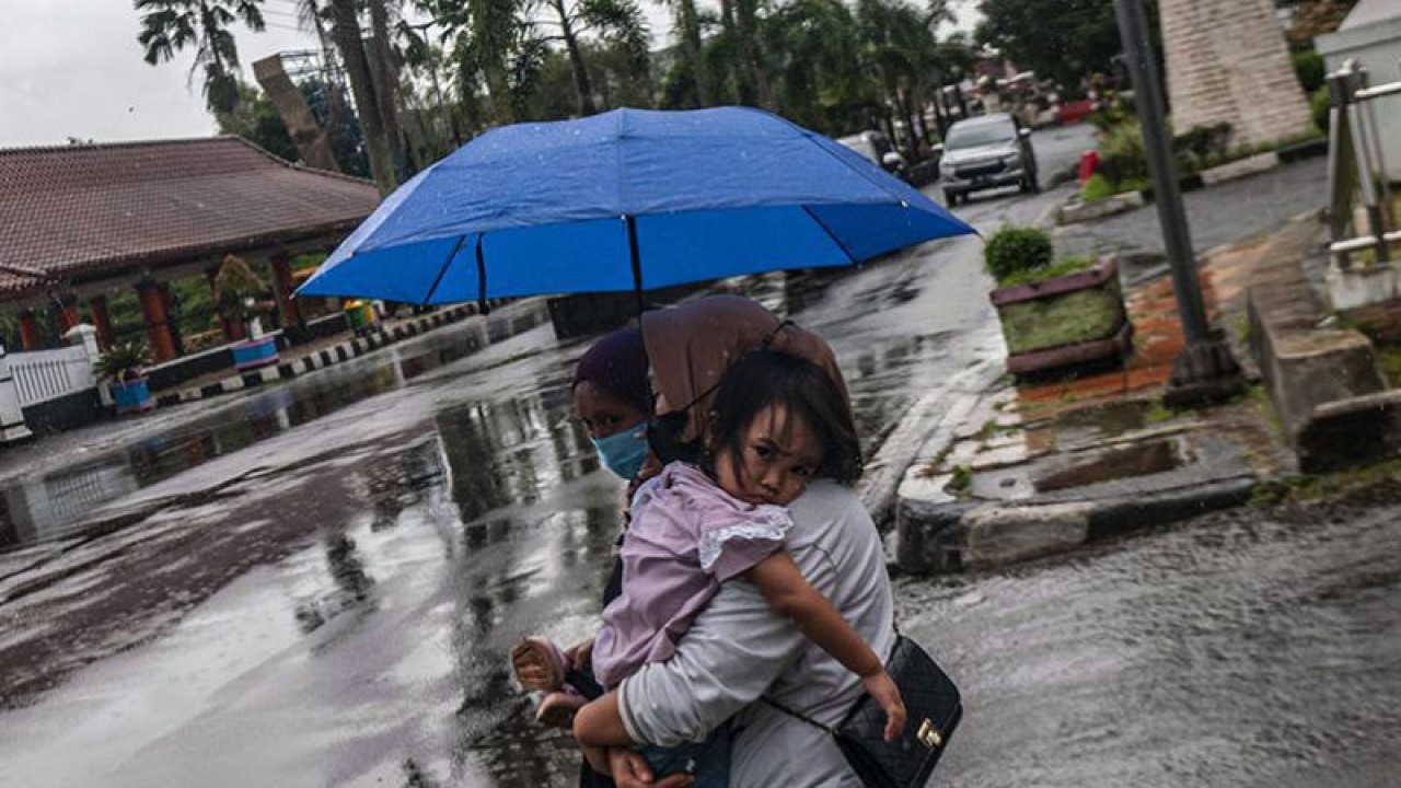 Warga menerobos hujan di Pandeglang, Banten, Senin (13/3/2023). Badan Meteorologi, Klimatologi dan Geofisika (BMKG) mengingatkan sejumlah wilayah Indonesia berpotensi mengalami hujan lebat yakni lebih dari 50 milimeter pada hari Senin (13/3). ANTARA FOTO/Muhammad Bagus Khoirunas/foc/pri. (ANTARA FOTO/MUHAMMAD BAGUS KHOIRUNAS)