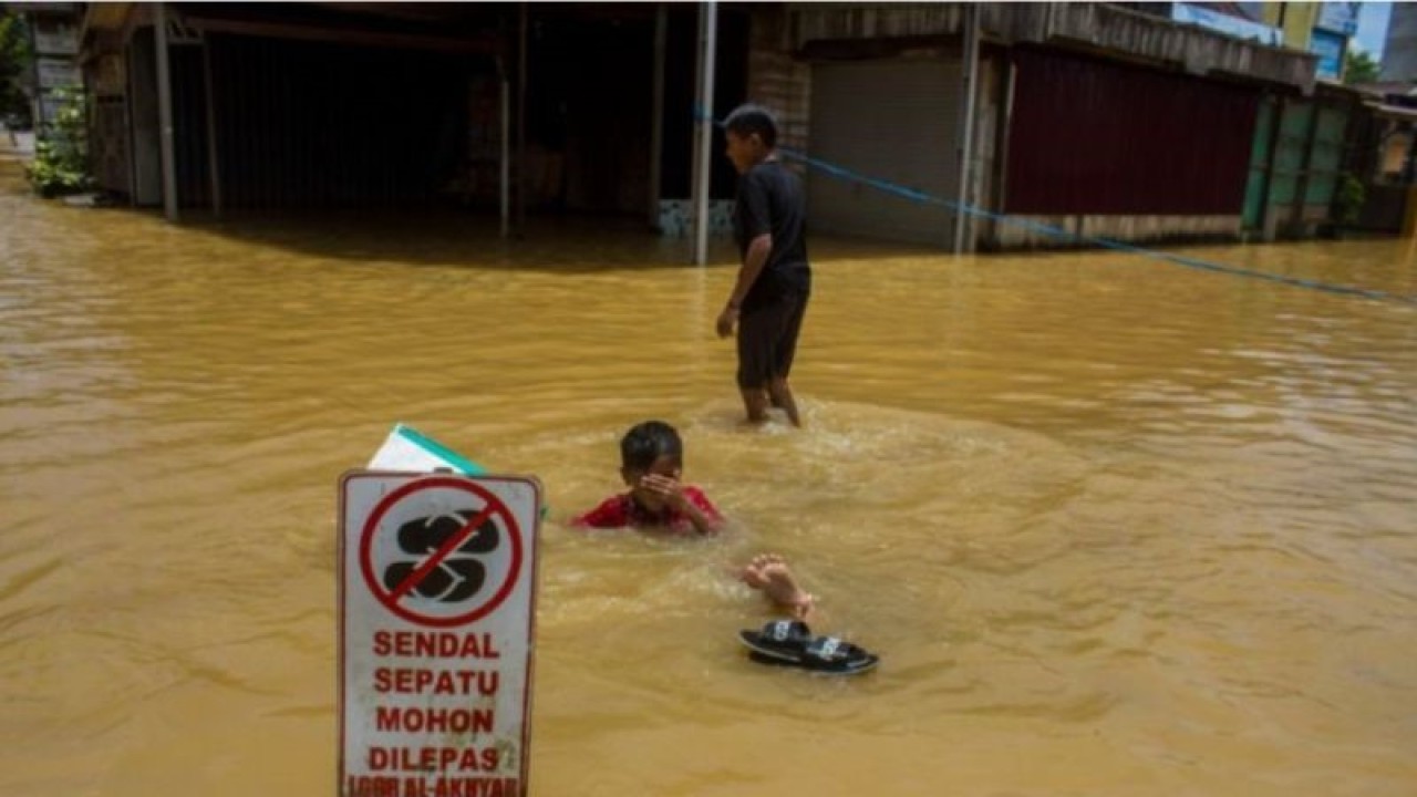 Ilustrasi: Anak-anak bermain air saat banjir di Barabai, Kabupaten Hulu Sungai Tengah, Kalimantan Selatan, Jumat (17/3/2023). Berdasarkan data BPBD Kabupaten Hulu Sungai Tengah pada Jumat (17/3/2023) sebanyak 4.188 jiwa dan 1.340 rumah di lima kecamatan terdampak banjir di kabupaten tersebut. ANTARA/Bayu Pratama S