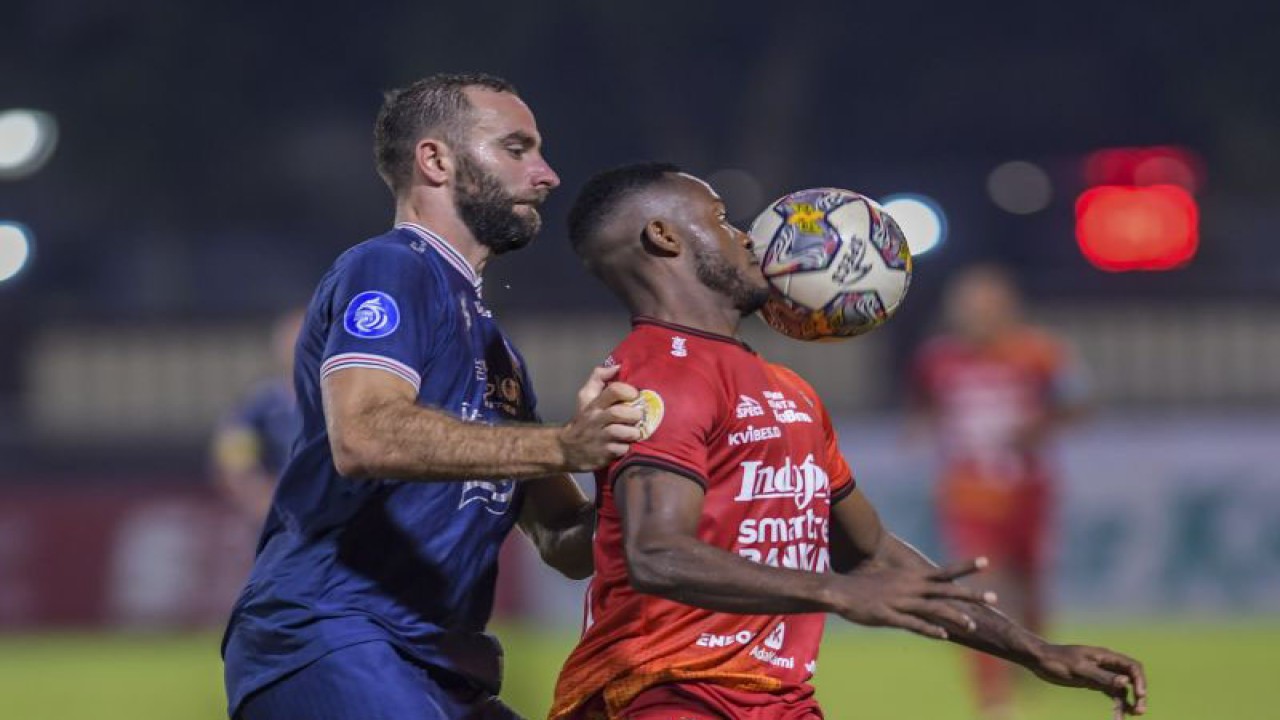 Pesepak bola Arema FC Sergio Domingos (kiri) menghadang pesepak bola Bali United FC Privat Mbarga (kanan) dalam lanjutan Liga 1 di Stadion PTIK, Jakarta, Senin (27/3/2023). Arema FC kalah atas Bali United FC dengan skor 1-3. ANTARA FOTO/Galih Pradipta/rwa. (ANTARA FOTO/GALIH PRADIPTA)