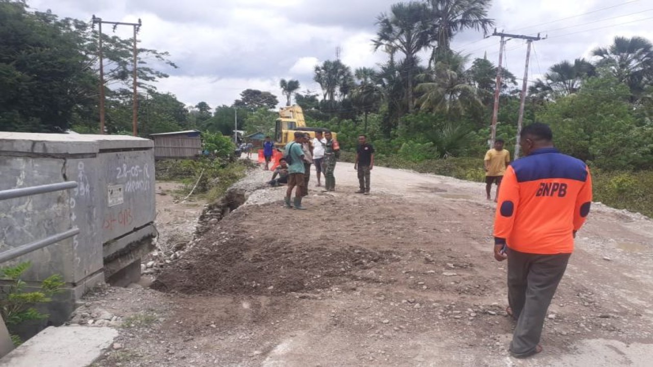 Petugas dari Badan Pelaksana Badan Penanggulangan Bencana Daerah (BPBD) dan Dinas Pekerjaan Umum dan Perumahan Rakyat (PUPR) Kabupaten Kupang Provinsi Nusa Tenggara Timur sedang memperbaiki bagian jembatan Bokong Lelogama-Takari yang rusak akibat tergerus air banjir, Jumat. (ANTARA/HO-BPBD Kabupaten Kupang)