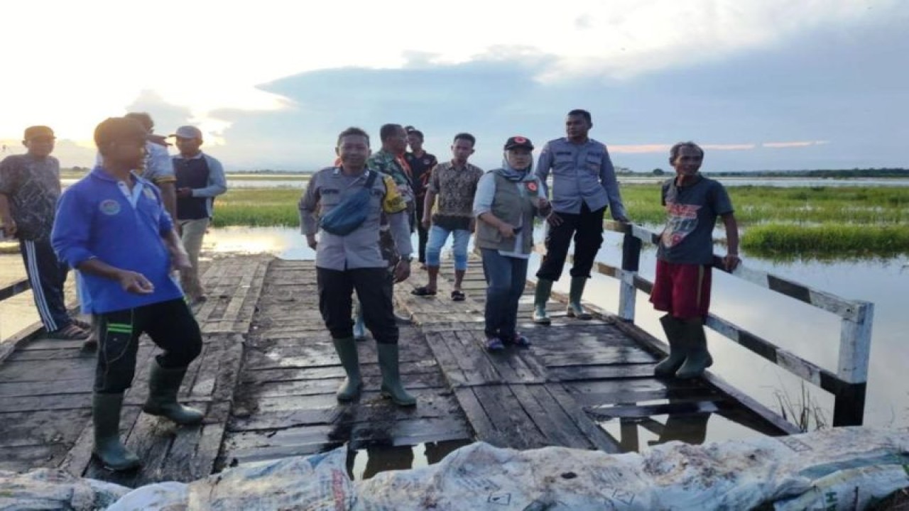 Tim dari Pusdalops BPBD Kabupaten Penajam Paser Utara bersama Bhabinkamtibmas, Babinsa, dan warga setelah menumpuk karung untuk membendung air di kawasan persawahan Desa Sumber Sari, Senin (20/3) (Antara/ HO Pusdalops BPBD PPU)