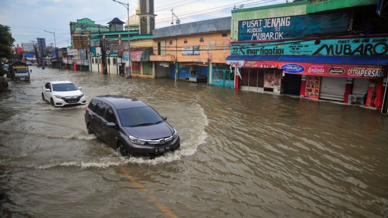 Sejumlah kendaraan menerobos jalan yang tergenang banjir di jalan nasional jalur Pantura (Pantai Utara) Desa Jati Wetan, Kudus, Jawa Tengah, Sabtu (4/3/2023). Banjir akibat curah hujan tinggi tersebut menyebabkan kemacetan dari arah Kudus menuju Semarang dan sebaliknya sejak Kamis (2/3). ANTARA FOTO/Yusuf Nugroho/nz (ANTARA FOTO/YUSUF NUGROHO)