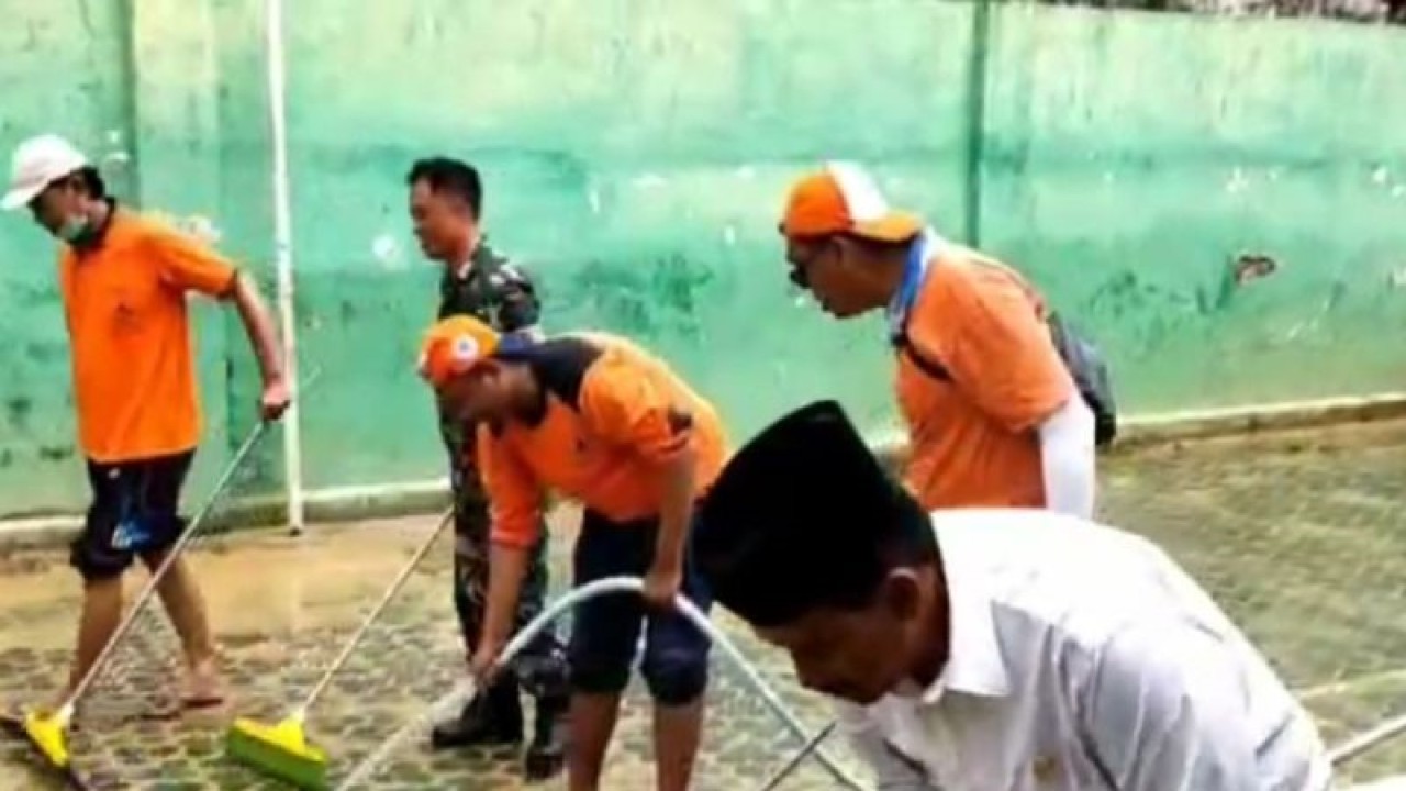Petugas membantu membersihkan lumpur sisa banjir di SDN Jungcangcang 5, Kabupaten Pamekasan, Provinsi Jawa Timur, Rabu (29/3/2023). (ANTARA/Abd. Aziz)