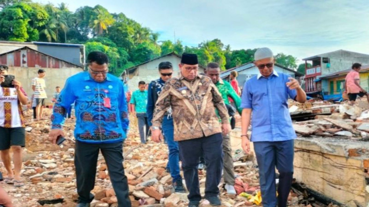 Penjabat Gubernur Papua Barat Daya Muhammad Musa'ad bersama rombongan melewati puing-puing bangunan sisa dari kebakaran hebat di Kampung Bugis, Kota Sorong. (ANTARA/Yuvensius Lasa Banafanu)