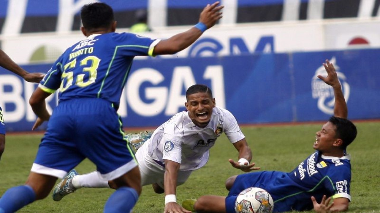 Pesepak bola Persib Bandung Dedi Kusnandar (kanan) menjatuhkan pesepak bola Persik Kediri Renan Silva (tengah) dalam pertandingan lanjutan BRI Liga 1 di Stadion Pakansari, Kabupaten Bogor, Jawa Barat, Rabu (8/3/2023). ANTARA FOTO/Yulius Satria Wijaya/nym. (ANTARA FOTO/YULIUS SATRIA WIJAYA)