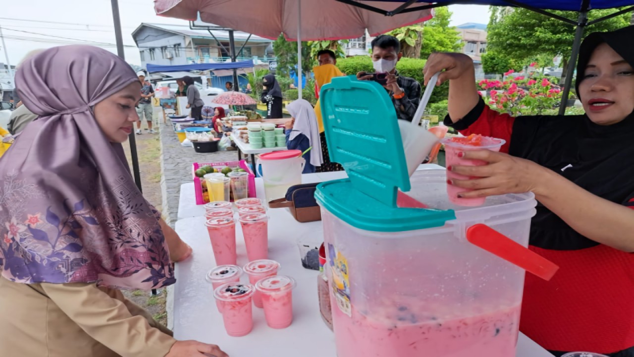 Seorang pedagang minuman menyiapkan pesanan Bupati Nunukan Asmin Laura Hafid (kiri) yang sedang berbelanja takjil Ramadhan, Sein (27/3/2023) di Nunukan, Kaltara. (FOTO ANTARA/HO-Dokpim Nunukan)