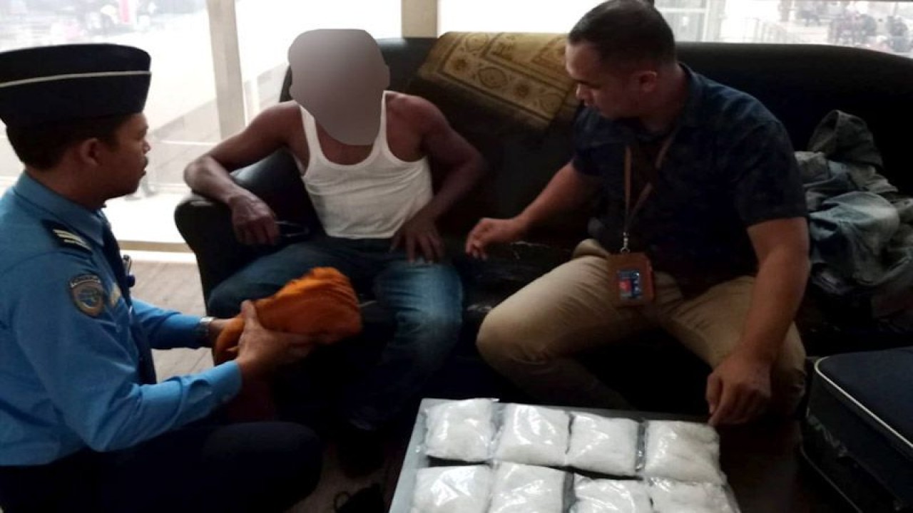 Prajurit Kodim 0101/KBA Kopda Fahrizal Amri (kanan) mendampingi petugas keamanan bandara (kiri) saat memeriksa penumpang pesawat (tengah) yang diduga membawa empat kilogram sabu-sabu di Bandara Kualanamu, Deli Serdang, Sumatera Utara, Selasa (28/2/2023). ANTARA/HO-Kodim 0101/KBA