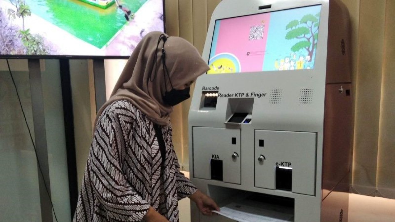Pegawai Dinas Kependudukan dan Pencatatan Sipil Kabupaten Kudus, Jawa Tengah, memperagakan mencetak kartu keluarga lewat Mesin Anjungan Kependudukan dan Catatan Sipil (Dukcapil) Mandiri. (FOTO ANTARA/Akhmad Nazaruddin Lathif)