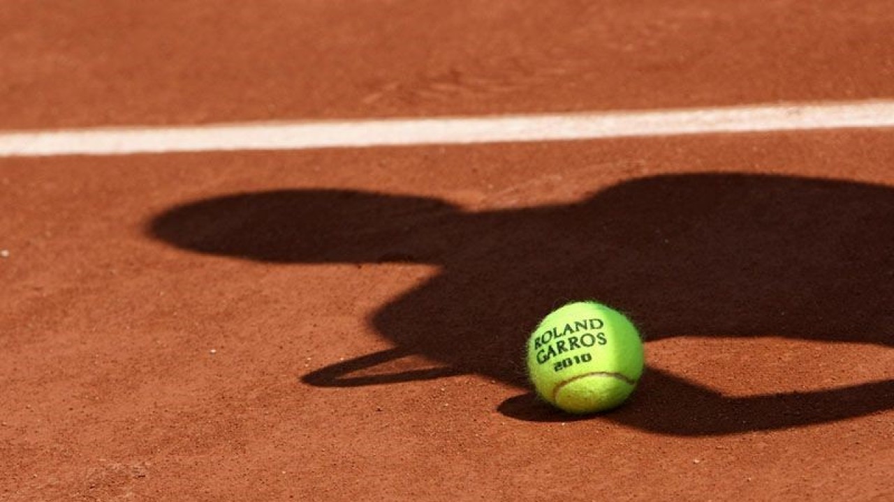 ilustrasi - Bola resmi turnamen tenis dengan bayang-bayang seorang pemain tenis diatas tanah. ANTARA/Shutterstock/pri.