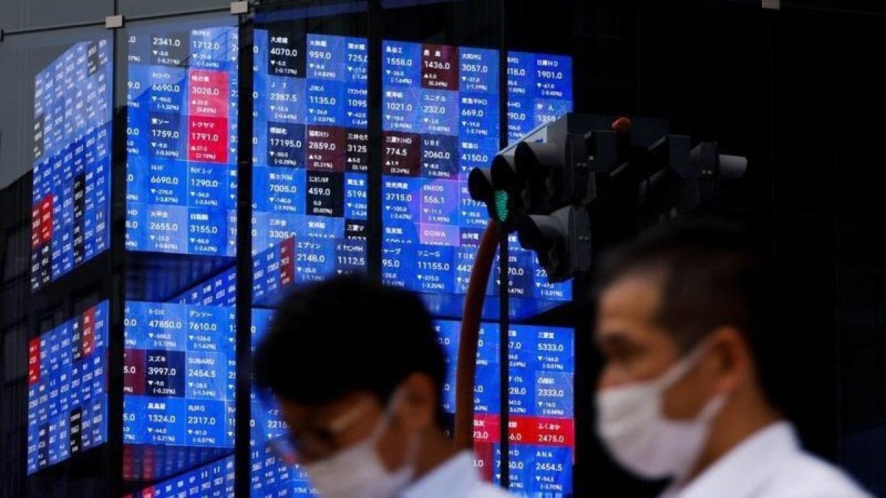 Arsip Foto - Orang-orang melewati layar elektronik yang menunjukkan indeks harga saham Nikkei Jepang di dalam sebuah aula konferensi di Tokyo, Jepang, Selasa (14/6/2022). (ANTARA/REUTERS/Issei Kato/am.)