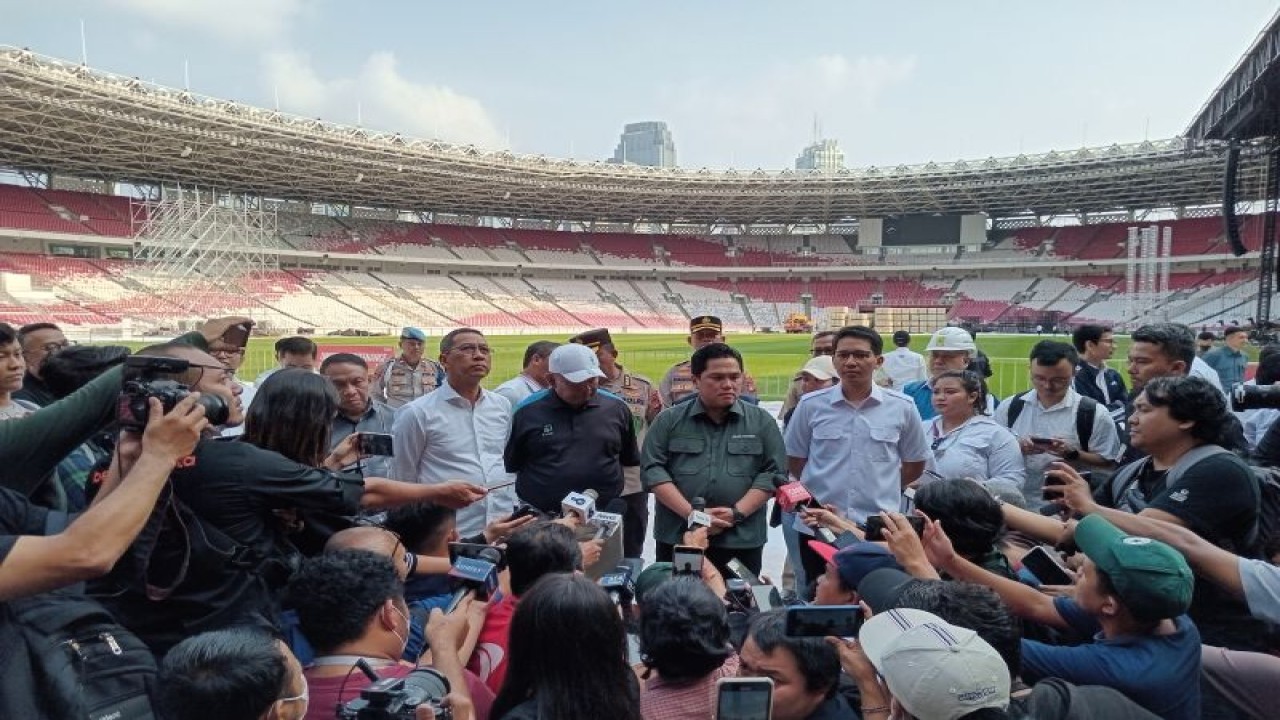 Ketua umum PSSI Erick Thohir (baju hijau) menjawab pertanyaan para pewarta setelah meninjau lapangan Stadion Utama Gelora Bung Karno, Jakarta, Senin (13/3/2023). (ANTARA/RAUF ADIPATI)