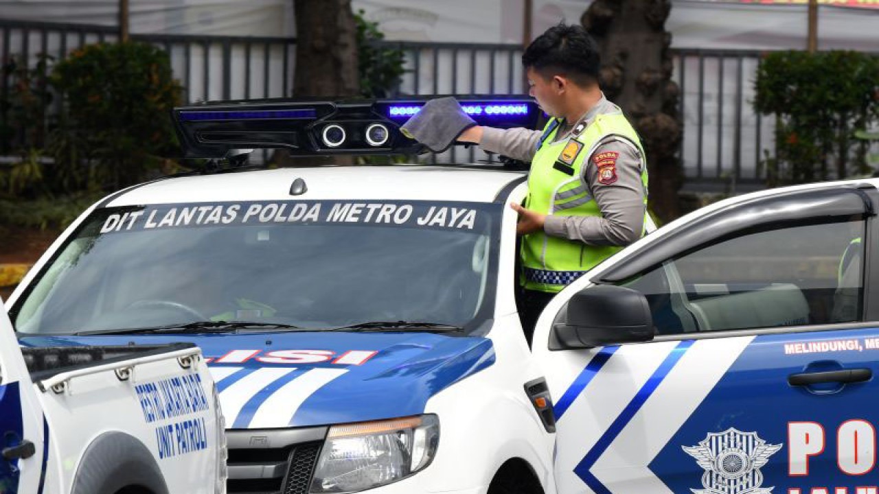 Polisi lalu lintas membersihkan kamera sistem tilang elektronik (ETLE) Mobile yang terpasang pada salah satu kendaraan patroli di Mapolda Metro Jaya, Jakarta, Selasa (13/12/2022). ANTARA FOTO/Aditya Pradana Putra/aww.