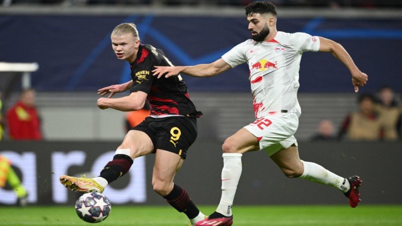 Pesepak bola Manchester City Erling Braut Haaland (kiri) mengoper bola ke arah rekannya dan dihadang pesepak bola RB Leipzig Josko Gvardiol (kanan) dalam laga leg pertama babak 16 besar Liga Champions, di Sadion Red Bull Arena, Leipzig, Jerman, Selasa (22/2/2023). Leipzig berhasil menahan  Manchester City 1-1 dalam pertandingan ini. ANTARA FOTO/Reuters-Annegret Hilse/hp.