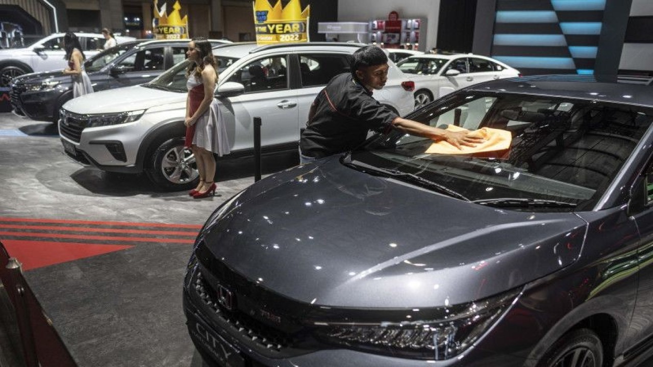 Petugas membersihkan kaca mobil yang dipamerkan di Gaikindo Jakarta Auto Week (GJAW) 2023 di JCC Senayan, Jakarta, Jumat (10/3/2023). (ANTARA FOTO/Aprillio Akbar/rwa)