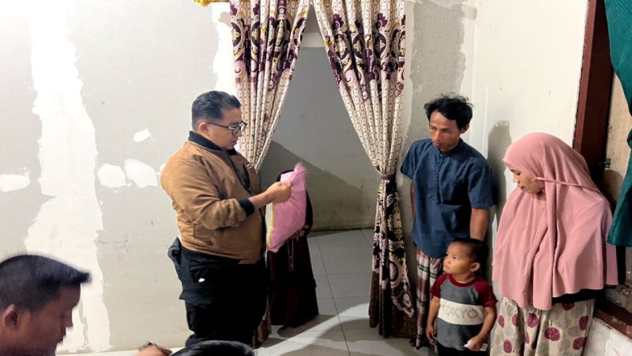 Penjabat Gubernur Sulbar Akmal Malik (kiri) menyerahkan bantuan saat melakukan kunjungan ke keluarga sasaran berisiko stunting di lokus stunting Kelurahan Sese, Kecamatan Simboro dan Kepulauan, Kabupaten Mamuju. (ANTARA/HO/Diskominfo Sulbar)