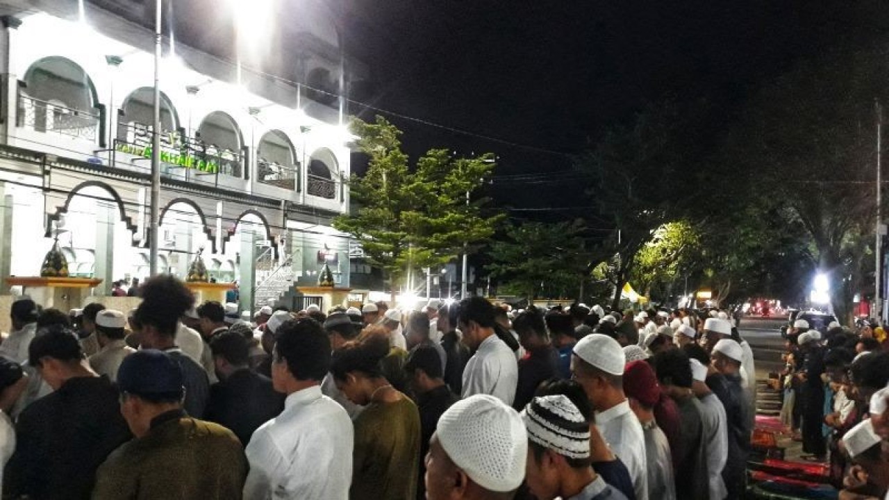 Jamaah Masjid Alkhairaat Palu, Sulawesi Tengah melaksanakan Shalat Isya dan Tarawih di badan Jalan Sis Aljufri, pada malam pertama Ramadhan 1443 Hijriah, Sabtu malam (2/3/2022). (ANTARA/Muhammad Hajiji)