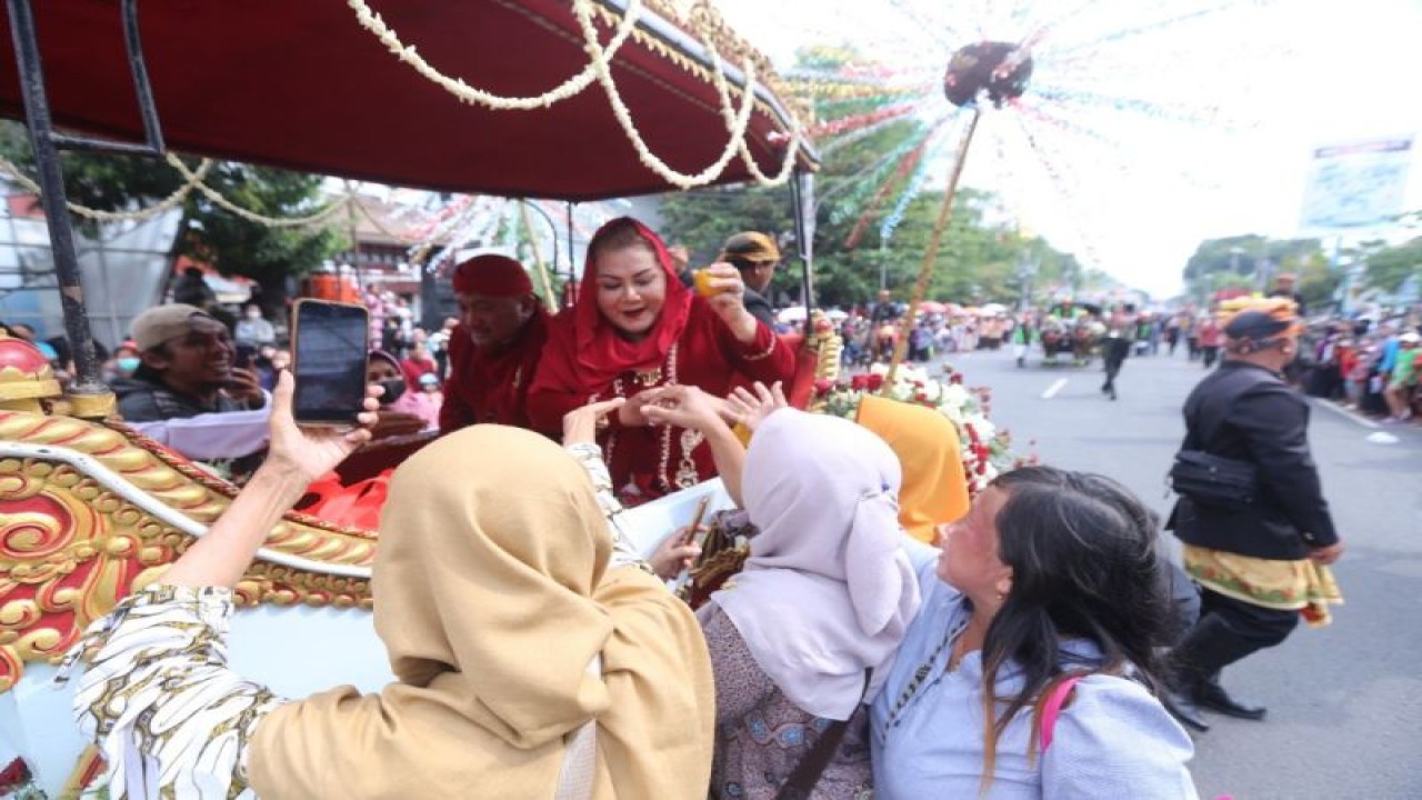 Wali Kota Semarang, Jateng, Hevearita Gunaryanti Rahayu beserta suami, diajak berfoto warga saat diarak menggunakan bendi pada pawai dugderan Semarang, Selasa (21/3/2023). (ANTARA/HO-Pemkot Semarang)