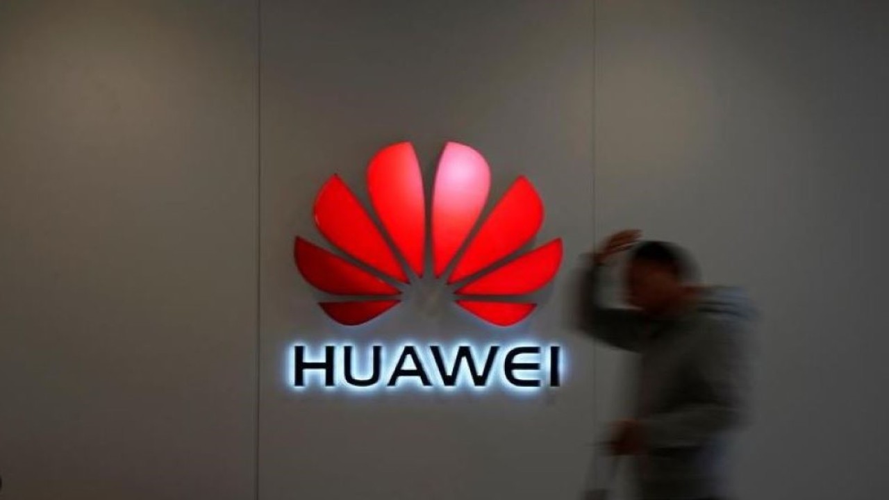 Seorang pria berjalan dengan logo Huawei di sebuah pusat perbelanjaan di Shanghai, China, 6 Desember 2018. (Aly Song/Reuters)