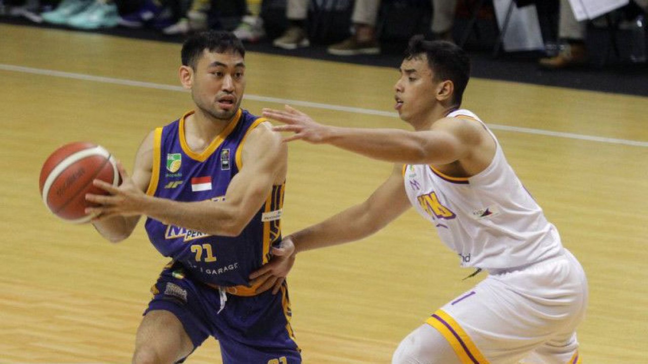 Pebasket Satria Muda Pertamina Jakarta Widyanta Putra Teja (kiri) berusaha melewati pebasket Tangerang Hawks Basketball Club Danny Ray (kanan) pada pertandingan Indonesian Basketball League (IBL) 2023 Seri III di DBL Arena, Surabaya, Jawa Timur, Senin (13/2/2023). Satria Muda Pertamina Jakarta mengalahkan Tangerang Hawks Basketball Club 76-67. ANTARA FOTO/Moch Asim/tom.