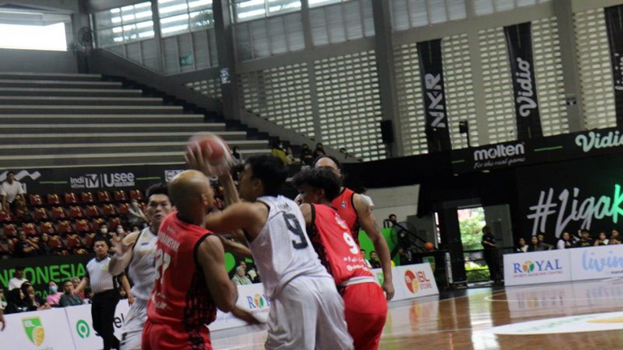 Pebola basket Bima Perkasa Ikram fadhil (kostum putih putih) dijaga ketat pebola basket Bali United (kastum merah-merah) saat melakukan tembakan ke ring dalam pertandingan IBL 2023 serin IV di Gor Sritex Arena Solo, Jawa Tengah, Sabtu (4/3/2023) petang. ANTARA/Bambang Dwi Marwoto.