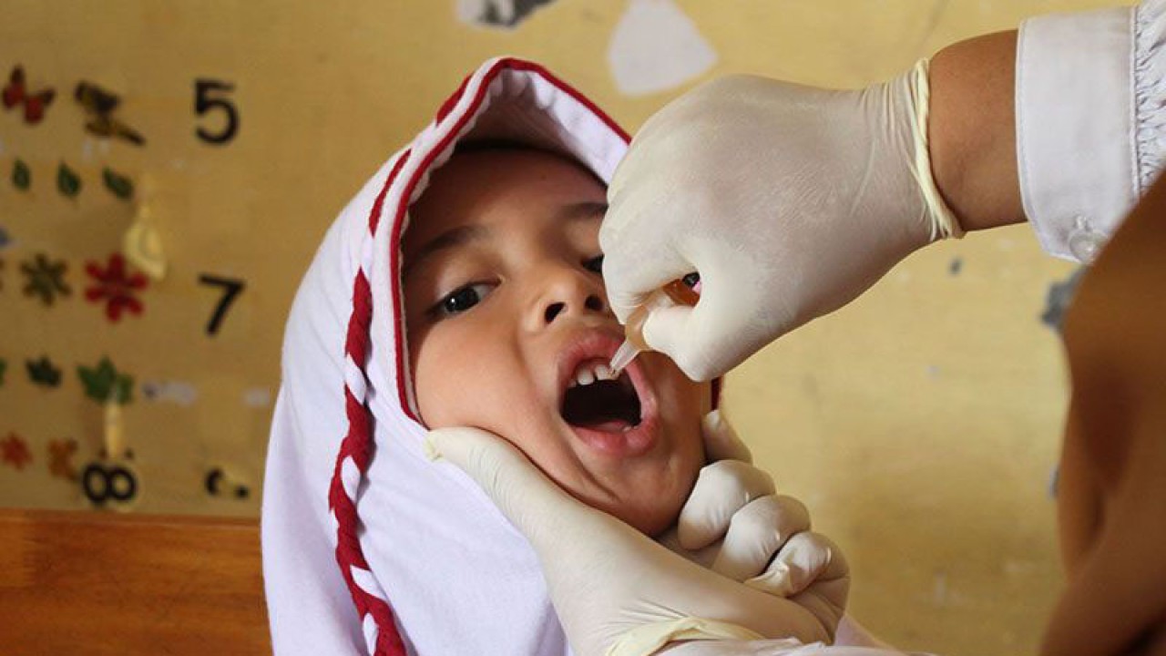 Petugas kesehatan memberikan tetesan vaksin polio tahap dua kepada pelajar di Sekolah Dasar Negeri 7, Banda Aceh, Senin (13/2/2023). ANTARA FOTO/Ampelsa