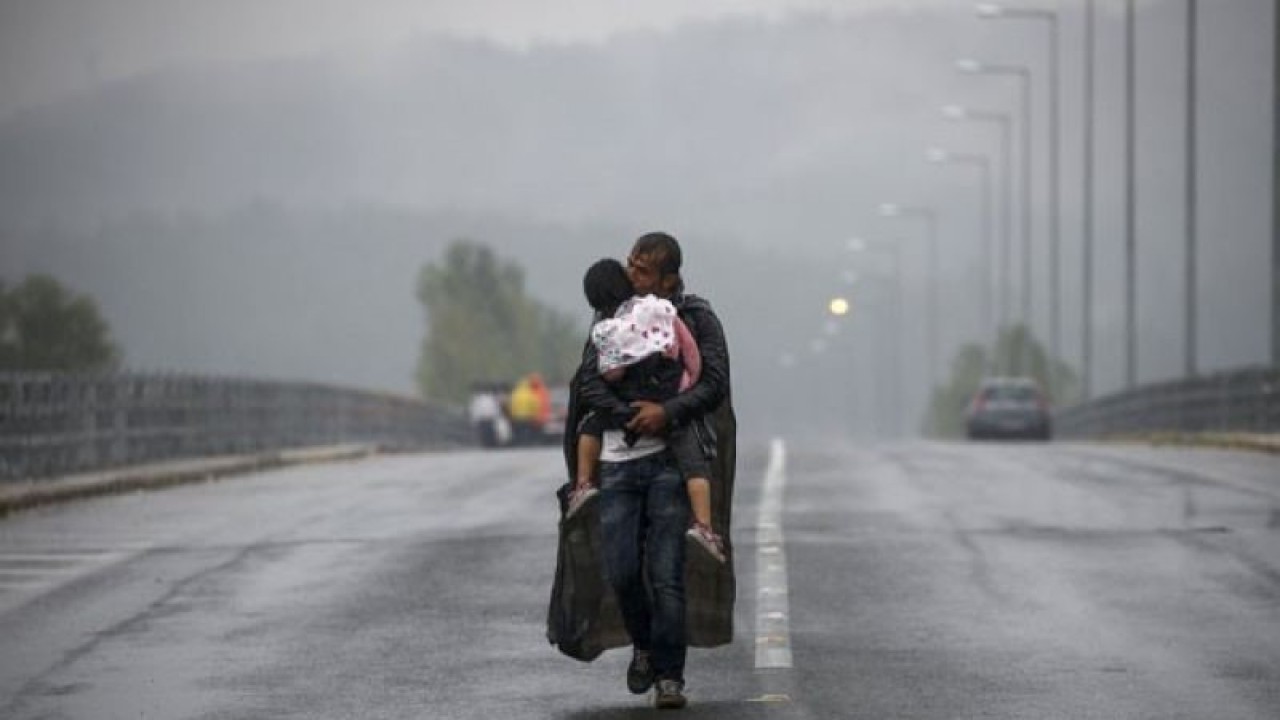 Arsip Foto - Pengungsi Suriah mencium putrinya saat berjalan di tengah badai hujan menuju perbatasan Yunani-Makedonia, dekat desa Idomeni, Yunani, Kamis (10/9//2015). ANTARA/REUTERS/Yannis Behrakis/am.