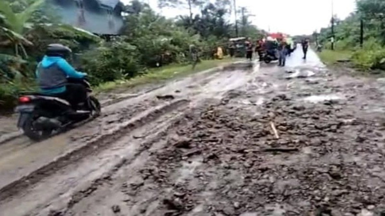 Pengendara sepeda motor melewati material longsor menimbun ruas jalan di Simeulue, Jumat (3/3/2023). ANTARA/HO/BPBD Simeulue