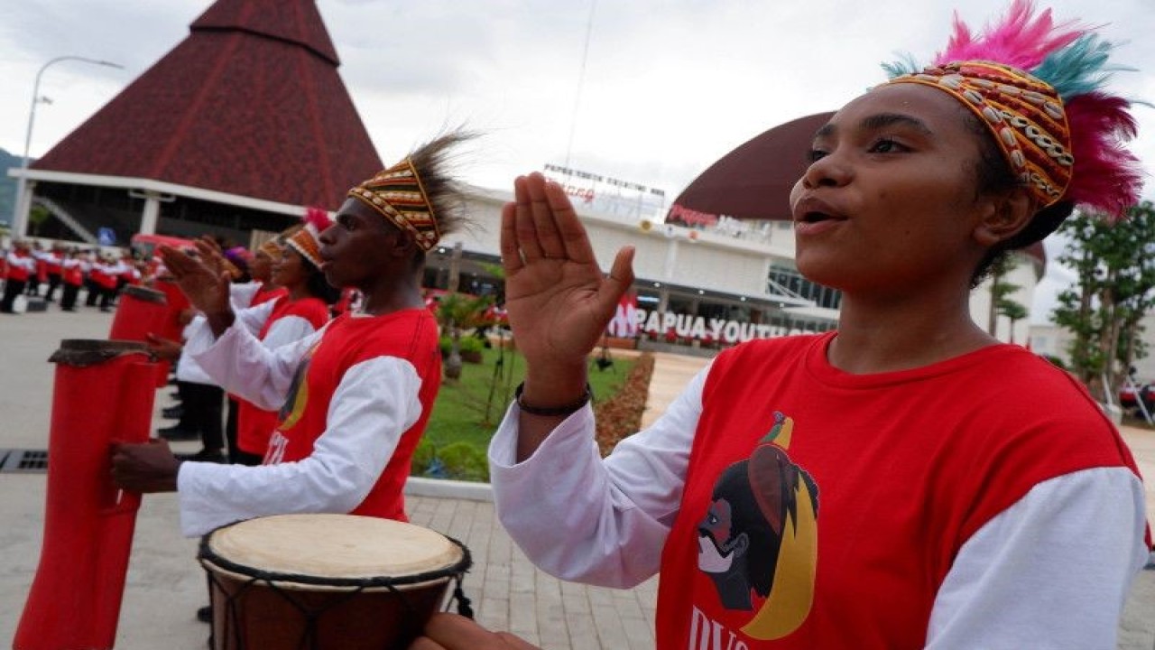 Sejumlah seniman memukul tifa saat latihan menari kolosal di lokasi kunjungan kerja Presiden Joko Widodo di halaman Gedung Papua Youth Creative Hub, Distrik Abepura, Kota Jayapura, Papua, Senin (20/3/2023). . ANTARA FOTO/Sakti Karuru/nym.