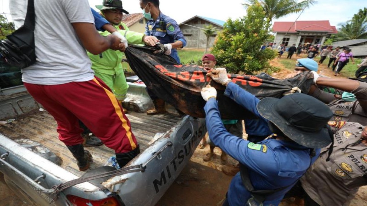 Anggota TNI, Polri, Damkar dan relawan mengangkat kantong berizi jenazah korban banjir bandang dan tanah longsor di Kampung Genteng, Desa Pangkalan, Kecamatan Serasan, Kabupaten Natuna, Kepulauan Riau, Rabu (8/3/2023). (Antara/HO-BNPB)