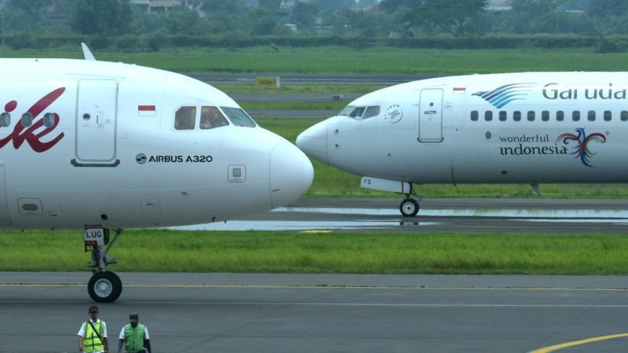 Petugas berjalan di dekat pesawat udara di Bandara Internasional Juanda Surabaya di Sidoarjo, Jawa Timur, Sabtu (4/3/2023). Menurut data Direktorat Jenderal Perhubungan Udara Kemenhub, hingga saat ini sebanyak 394 pesawat udara telah disiapkan untuk penerbangan reguler dan akan bertambah pada saat pelaksanaan angkutan udara Lebaran 2023 mendatang. ANTARA FOTO/Fikri Yusuf/nz