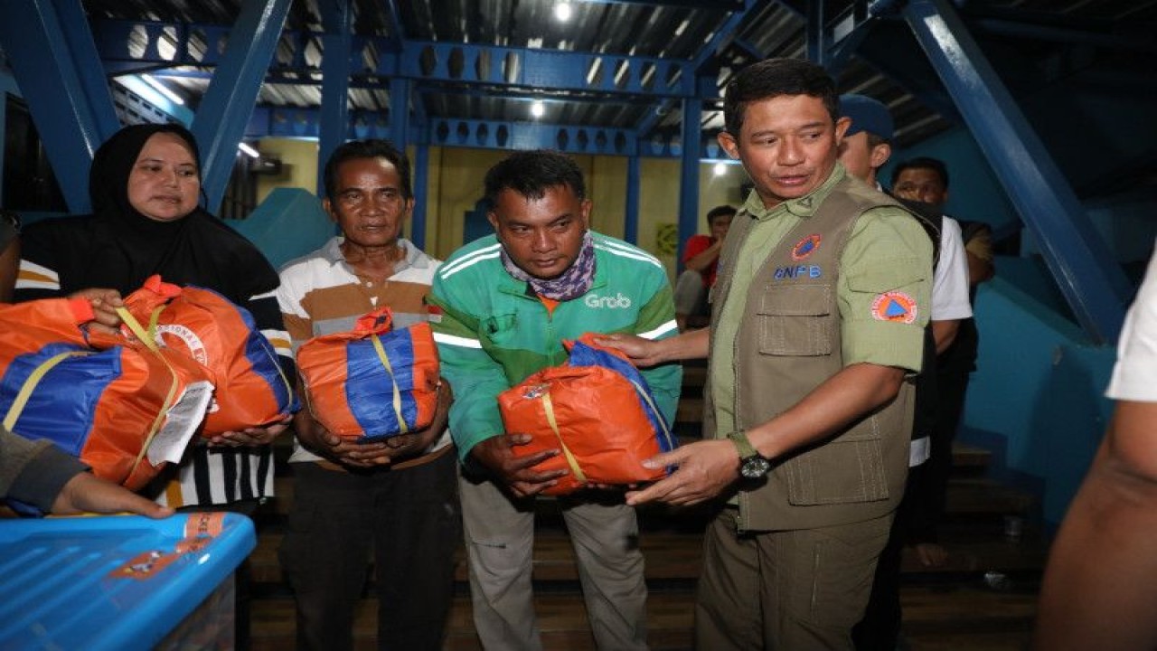 Kepala BNPB Letjen TNI Suharyanto (baju hijau rompi) memberikan bantuan secara simbolis untuk percepatan penanganan bencana tanah longsor di Kampung Sirna Sari RT 07 RW 04, Kelurahan Empang, Kecamatan Bogor Selatan, Kota Bogor, Jawa Barat, Rabu (15/3/2023). (ANTARA/HO-BNPB)