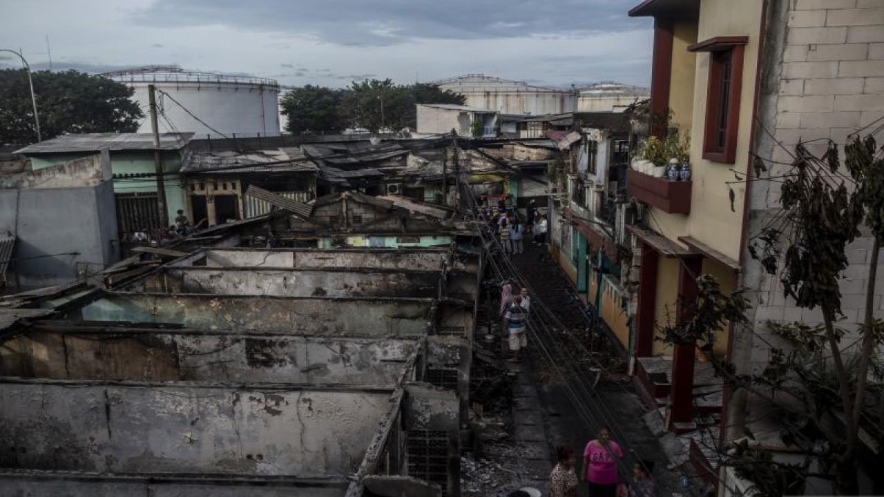 Sejumlah warga berada di dekat permukiman penduduk yang hangus terbakar dampak kebakaran Depo Pertamina Plumpang di Jalan Koramil, Rawa Badak Selatan, Koja, Jakarta, Sabtu (4/3/2023). Belasan warga dilaporkan menjadi korban jiwa dalam peristiwa itu. ANTARA FOTO/Aprillio Akbar/foc.