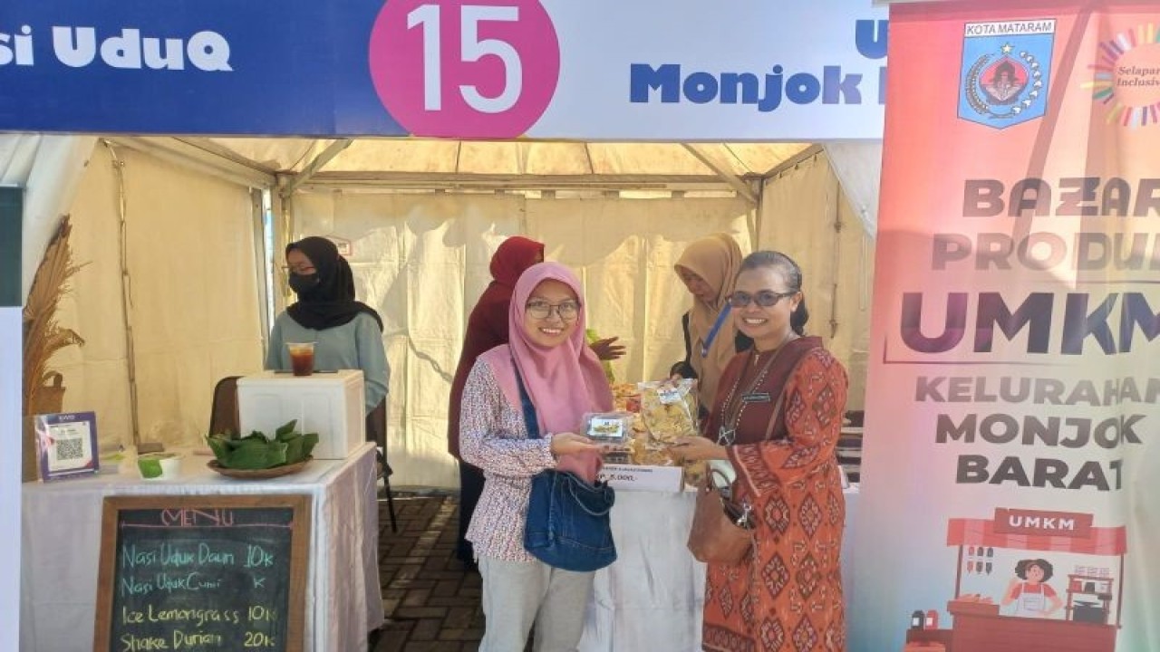 Kepala KPP Pratama Mataram Barat, Devy Sonya Adrince (kanan), menunjukkan produk UMKM binaannya yang dipromosikan pada Bazar UMKM Kementerian keuangan di Mataram, Jumat (10/3/2023). ANTARA/Awaludin)