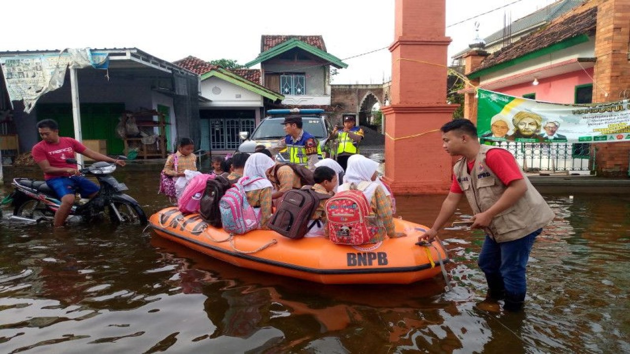 Siswa yang hendak ke sekolah terpaksa diantar dengan perahu karet agar pakaiannya tidak basah. Tingginya genangan banjir mengakibatkan jumlah pengungsi juga bertambah. (ANTARA/HO-BPBD Kds.)