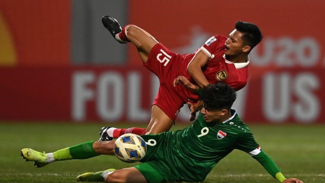 Pemain Timnas U-20 Indonesia Dzaky Asraf (atas) terjatuh saat berebut bola dengan pemain Timnas U-20 Irak Mustafa Qabeel dalam kualifikasi Grup A Piala Asia U-20 di Stadion Lokomotiv, Tashkent, Uzbekistan, Rabu (1/3/2023). . ANTARA FOTO/Sigid Kurniawan/foc. (ANTARA FOTO/SIGID KURNIAWAN)