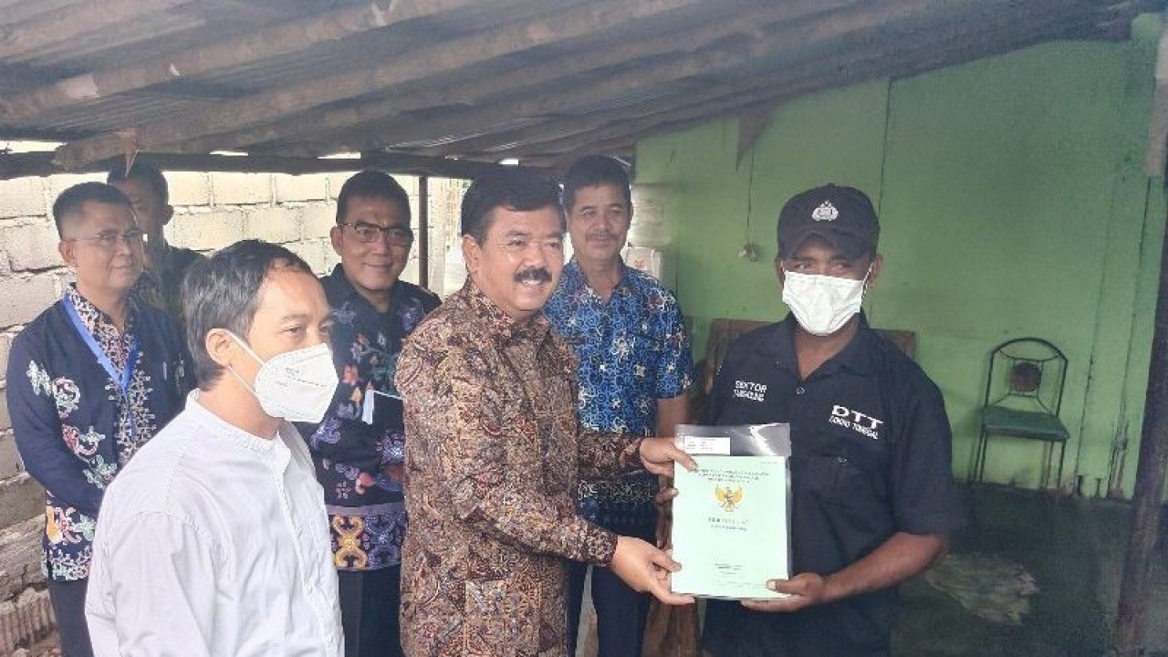 Menteri ATR/BPN, Hadi Tjahjanto menyerahkan sertipikat tanah hasil Program PTSL langsung ke rumah warga di Kelurahan Banturung, Kecamatan Bukit Batu, Palangka Raya, Kalimantan Tengah, Jumat, (24/3). (ANTARA/Muhammad Arif Hidayat)