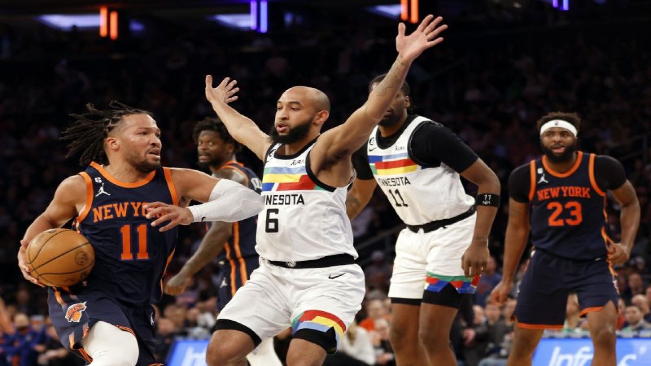 Pebasket New York Knicks Jalen Brunson (kiri) mencoba melewati hadangan pebasket Minnesota Timberwolves Jordan McLaughlin (tengah) saat pertandingan NBA kedua tim di Madison Square Garden, New York City, Senin (20/3/2023) waktu setempat (Getty Images via AFP/SARAH STIER)