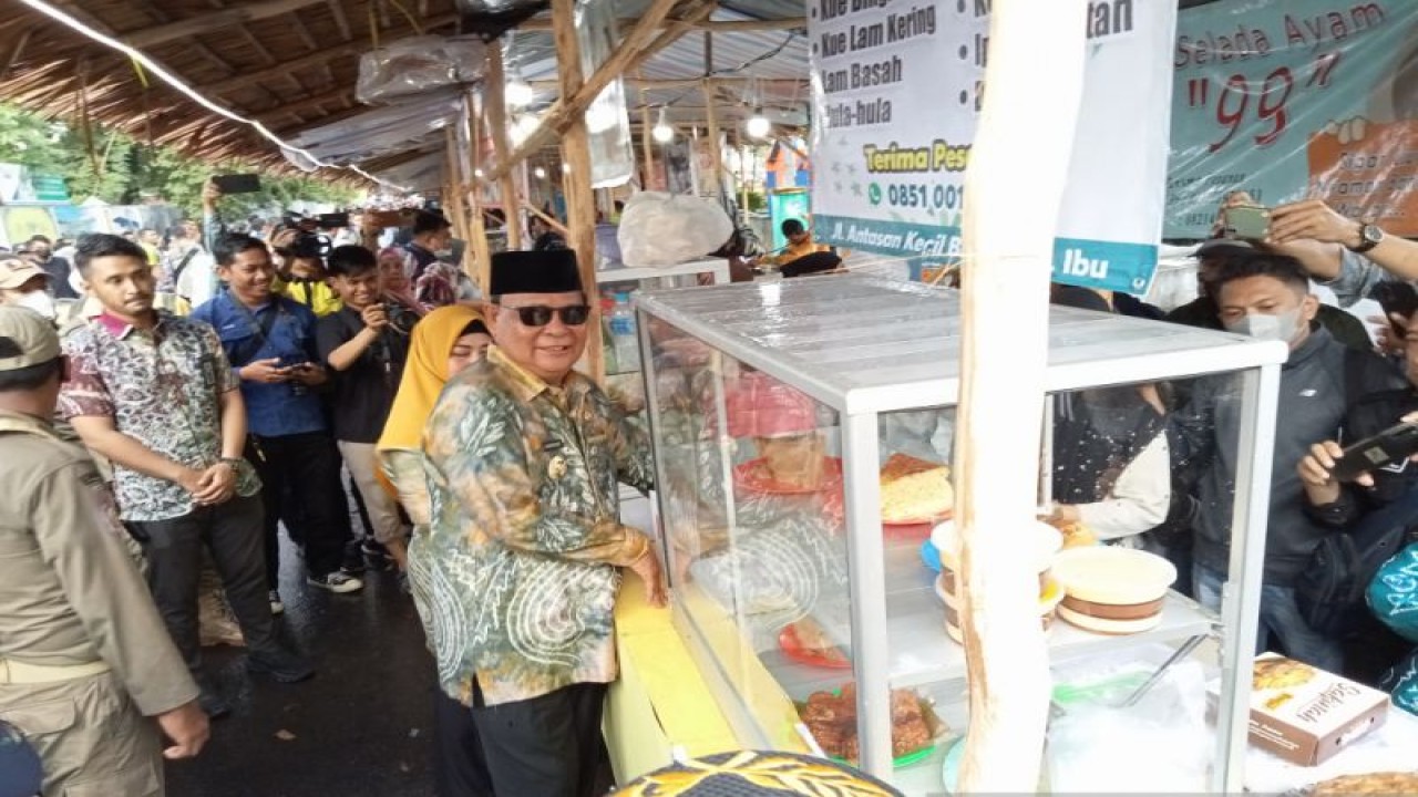 Gubernur Kalsel H Sahbirin Noor bersama istri saat mengunjungi salah satu stand di pasar wadai Ramadhan 1444 H di jalan Sudirman atau depan kantor eks Gubernur Kalsel di Banjarmasin, Kamis (23/3/2023). (ANTARA/Sukarli)