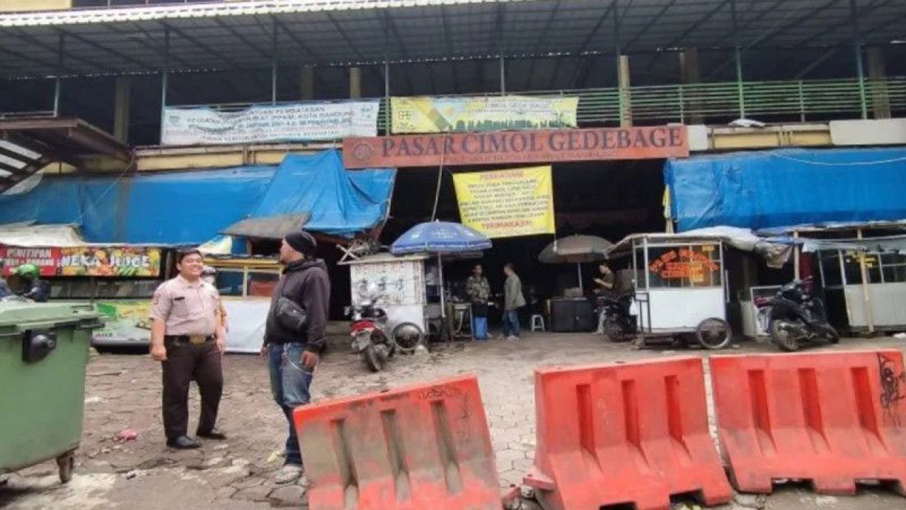 Petugas keamanan melakukan sosialisasi penutupan pasar di Pasar Cimol Gedebage, Kota Bandung, Jawa Barat, Rabu (22/3/2023). (ANTARA/Bagus Ahmad Rizaldi)